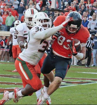 Virginia tight end Jake McGee (83) hauls in the game-winning touchdown pass as Miami linebacker Gionni Paul (36) tries to defend during the second...