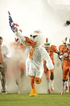 Sebastian the Ibis leads the University of Miami Hurricanes through a tunnel of smoke in a game against the Virginia Tech Hokies at Sun Life Stadium...