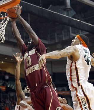 Boston College's Reggie Jackson (0) is fouled as he goes to the basket by Miami's Julian Gamble, right, during the second half of an NCAA college...