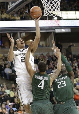 Wake Forest's Devin Thomas (2) shoots over Miami's Trey McKinney Jones (4) and Tonye Jekiri (23) during the first half of an NCAA college basketball...