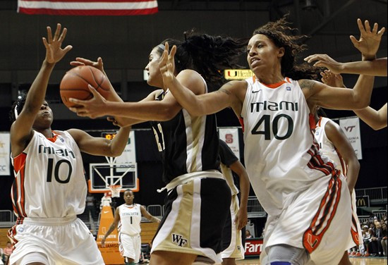 Wake Forest's Sandra Garcia grabs a rebound over Miami's Michelle Woods (10) and Shawnice Wilson. (AP Photo/Lynne Sladky)