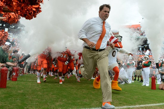 Sebastian the Ibis and coach Al Golden leads the University of Miami Hurricanes through a tunnel of smoke in a game against the #12 ranked University...