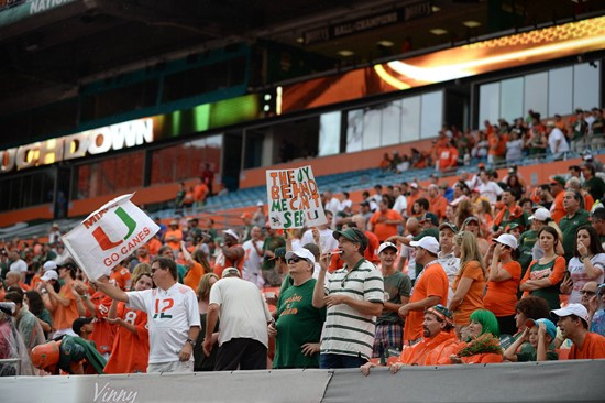 University of Miami Hurricanes fans celebrate after the Canes score a touchdown in a game against the Virginia Cavaliers at Sun Life Stadium on...