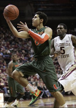 Miami's Shane Larkin drives the lane and beats the defense of Florida State's Benard James in the first half of an NCAA college basketball game on...