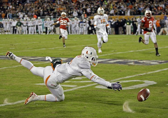 Miami running back Javarris James dives for a pass from quarterback Jacory Harris during the first half of the Champs Sports Bowl NCAA college...