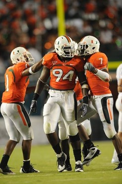 University of Miami Hurricanes defensive end Eric Moncur #94 celebrates with Brandon Harris #1 and Vaughn Telemaque #7 after making a tackle in a game...