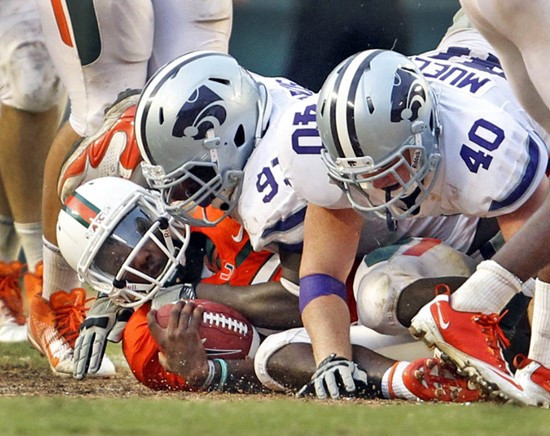Miami quarterback Jacory Harris, bottom left, is tackled by the Kansas State defensivemen in the fourth quarter of an NCAA college football game...