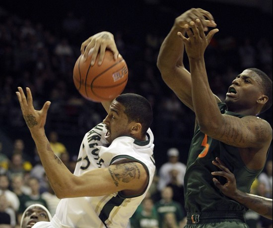 Charlotte's Pierria Henry, left, grabs a rebound from Miami's DeQuan Jones, right, during the first half of an NCAA college basketball game in...