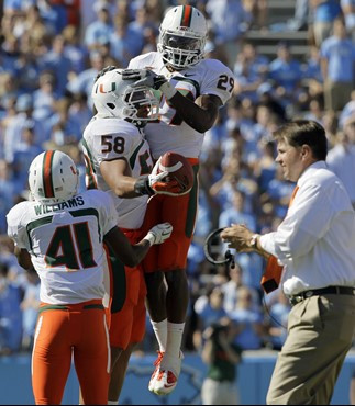 Miami's JoJo Nicolas (29), Jordan Futch (58) and Mike Williams (41) celebrate after Futch's fumble recovery against North Carolina. (AP Photo/Gerry...