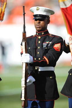 A U.S. Marine soldier stands at attention as the national anthem is played at Sun Life Stadium before a game between the Virginia Tech Hokies and the...