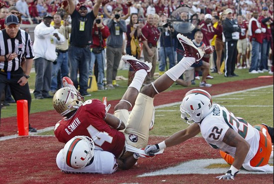 Florida State wide receiver Rodney Smith (84) comes down on top of Miami defensive back Lee Chambers (32) as defensive back Kacy Rodgers (22) can't...