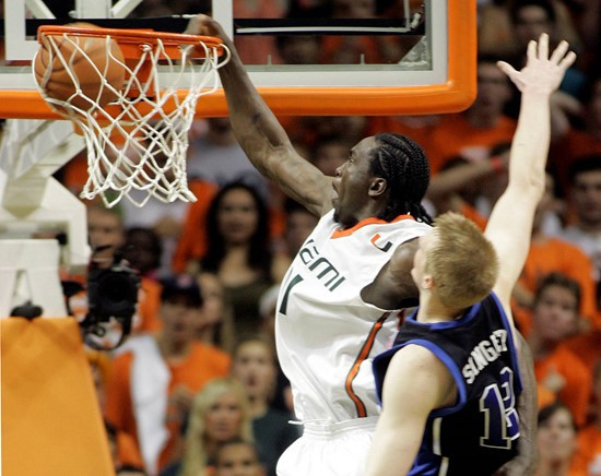Dwayne Collins, left, dunks as Duke's Kyle Singler (12) defends in the second half of a basketball game in Coral Gables, Fla., Wednesday, Feb. 20,...