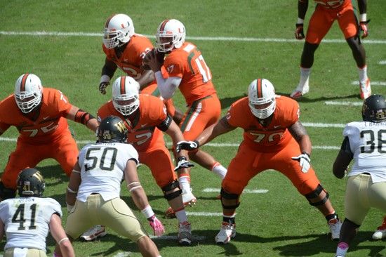 University of Miami Hurricanes offensive line gets set to block for Stephen Morris in a game against the Wake Forest Demon Deacons at Sun Life Stadium...