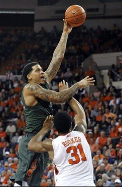Miami's Julian Gamble shoots over Clemson's Devin Booker (31) in the second half of an NCAA college basketball game, Sunday, Feb. 17, 2013, in...