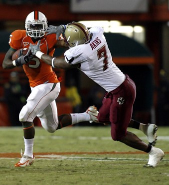 Miami running back Javarris James stiff arms Boston College's Kevin Akins (7) during the second quarter of a college football game, Thursday, Nov. 23,...