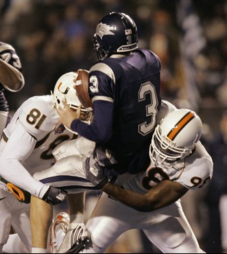 Nevada quarterback Jeff Rowe is sacked by Miami defensive end Calais Campbell and defensive lineman Baraka Atkins during the first quarter of the MPC...