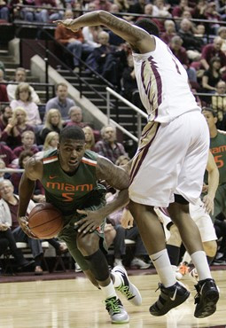 Miami's Dequan Jones tries to go under the defense of Florida State's Xavier Gibson in the first half of an NCAA college basketball game on Saturday,...
