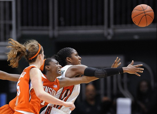 Miami's Shenise Johnson, right, and Clemson's Riquana Williams, center, reach for a loose ball during the second half of an NCAA college basketball...