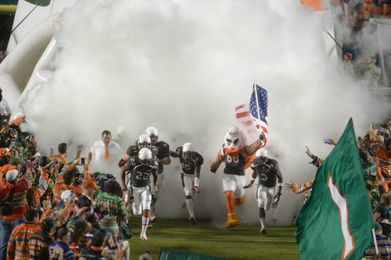 Sebastian the Ibis leads the University of Miami Hurricanes through a tunnel of smoke in a game against the Virginia Tech Hokies at Sun Life Stadium...