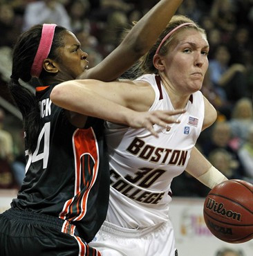 Boston College's Carolyn Swords (30) makes a move against Miami's Sylvia Bullock (34) during the second half of an NCAA basketball game in Boston,...