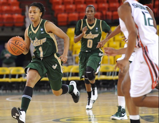 South Florida's Jasmine Wynne (1) dribbles upcourt with Miami's Krystal Saunders (12) looking on. (AP Photo/Michael Dinneen)