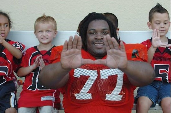 University of Miami offensive lineman Seantrel Henderson #77 sits with the Kendall Hammocks Warriors Pee Wee football team after they worked out...