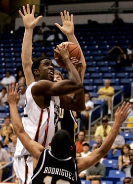 Brian Asbury works under the nets against pressure from VCU's Kirill Pischalnikovh, rear, and Joey Rodriguez. (AP Photo/Andres Leighton)