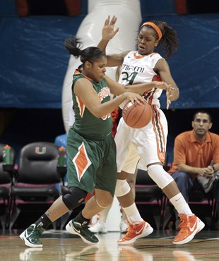 Texas-Pan American's Keandra Goodson, left, fouls Miami's Sylvia Bullock (34) in the first half of an NCAA college basketball game in Coral Gables,...