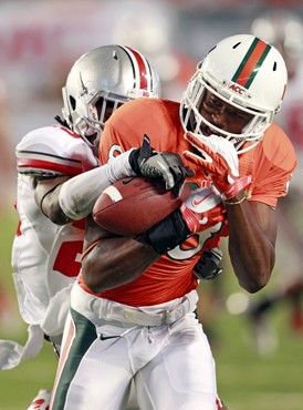Miami wide receiver Tommy Streeter, foreground, pulls in a pass in front of Ohio State defensive back Bradley Roby during the second quarter of an...