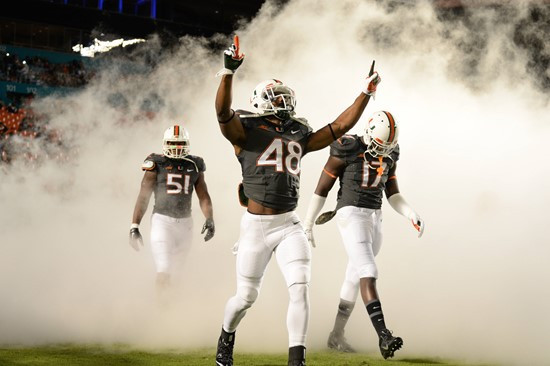 Sebastian the Ibis leads the University of Miami Hurricanes through a tunnel of smoke in a game against The Pittsburgh Panthers at Sun Life Stadium on...