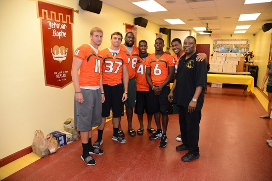 Players pose for a photo with Pastor Willie Williams