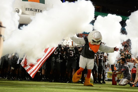 Sebastian the Ibis leads the University of Miami Hurricanes through a tunnel of smoke in a game against the Duke Blue Devils at Sun Life Stadium on...