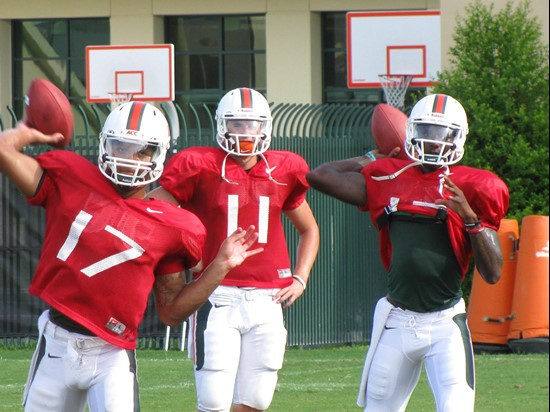 Ryan Williams looks on as fellow quarterbacks Stephen Morris and Jacory Harris participate in a passing drill.