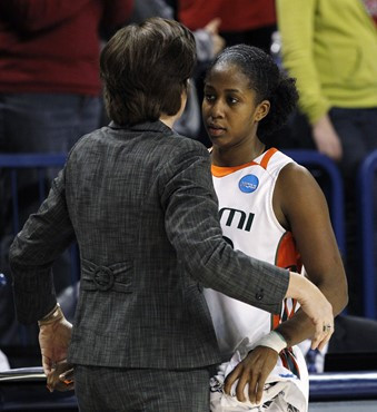 Miami's Shenise Johnson, right, is embraced by coach Katie Meier as Johnson leaves the game late in the second half of an NCAA tournament second-round...