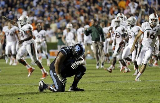 North Carolina's Landon Turner (78) kneels following North Carolina's loss to Miami in an NCAA college football game in Chapel Hill, N.C., Thursday,...