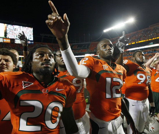 Javarris James, Damien Berry and Jeremy Lewis celebrate after Miami's 21-20 victory.