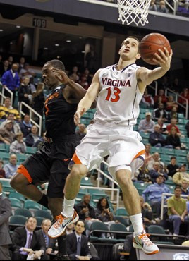 Virginia's Sammy Zeglinski (13) drives past Miami's Durand Scott (1) in the first half of an NCAA college basketball game at the Atlantic Coast...