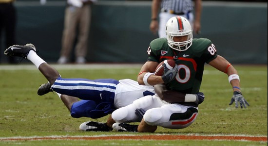 Miami's Jimmy Graham (80) is tackled by Duke safety Matt Daniels during the quarter of an NCAA college football game in Miami, Saturday, Nov. 21,...