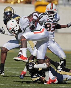 Miami running back Graig Cooper (2) can't escape from Georgia Tech cornerback Mario Butler (2) in the second quarter of an NCAA college football game...