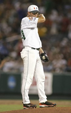 Miami's Carlos Gutierrez wipes his face in the ninth inning against Georgia in an NCAA College World Series baseball game, in Omaha, Neb., Saturday,...
