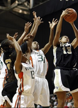 Wake Forest's Mykala Walker (13) grabs a rebound over Miami's Krystal Saunders (12) and Sylvia Bullock. (AP Photo/Lynne Sladky)