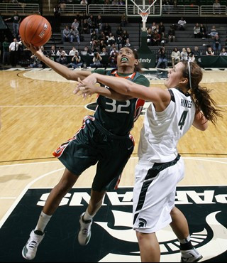 Miami's Morgan Stroman (32) puts up a shot and draws a foul against Michigan State's Jasmine Hines (4) during the second half. (AP Photo/Al Goldis)