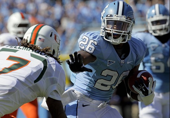 North Carolina's Giovani Bernard (26) runs the ball as Miami's Vaughn Telemaque (7) moves in for the tackle. (AP Photo/Gerry Broome)