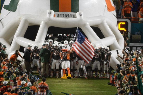 Sebastian the Ibis leads the University of Miami Hurricanes through a tunnel of smoke in a game against the Virginia Tech Hokies at Sun Life Stadium...