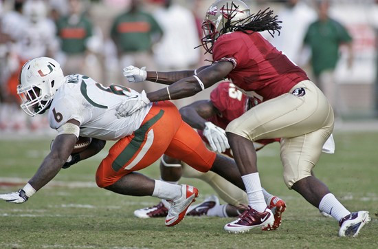 Miami running back Lamar Miller (6) dives for a first down as Florida State safety Terrance Parks (4) pursues during the second quarter of an NCAA...