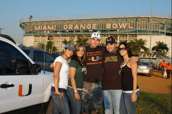 University of Miami Hurricane fans pose for a photograph before a game between the Miami Hurricanes and the Virginia Cavaliers at the Orange Bowl on...